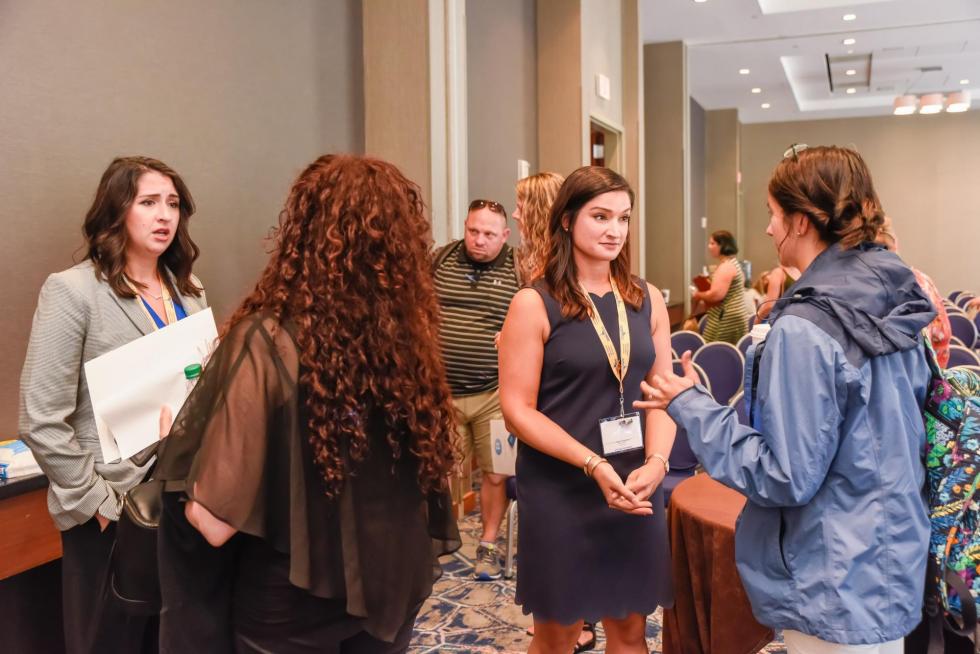 Picture of Kristen Cassidy and Kari Hankins speaking with attendees at the 2019 Making  Schools Work Conference
