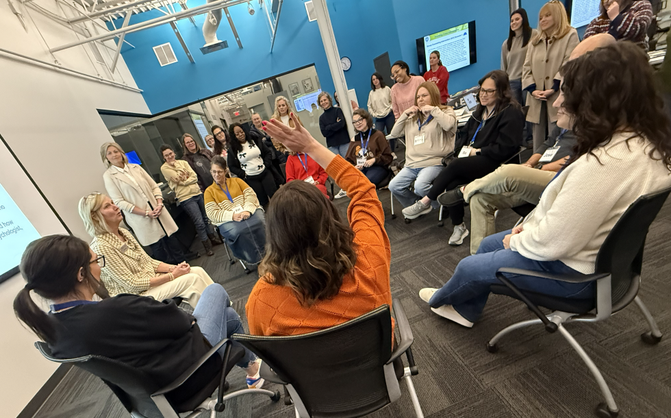 one person with a raised hand in a group of people sitting in a circle 