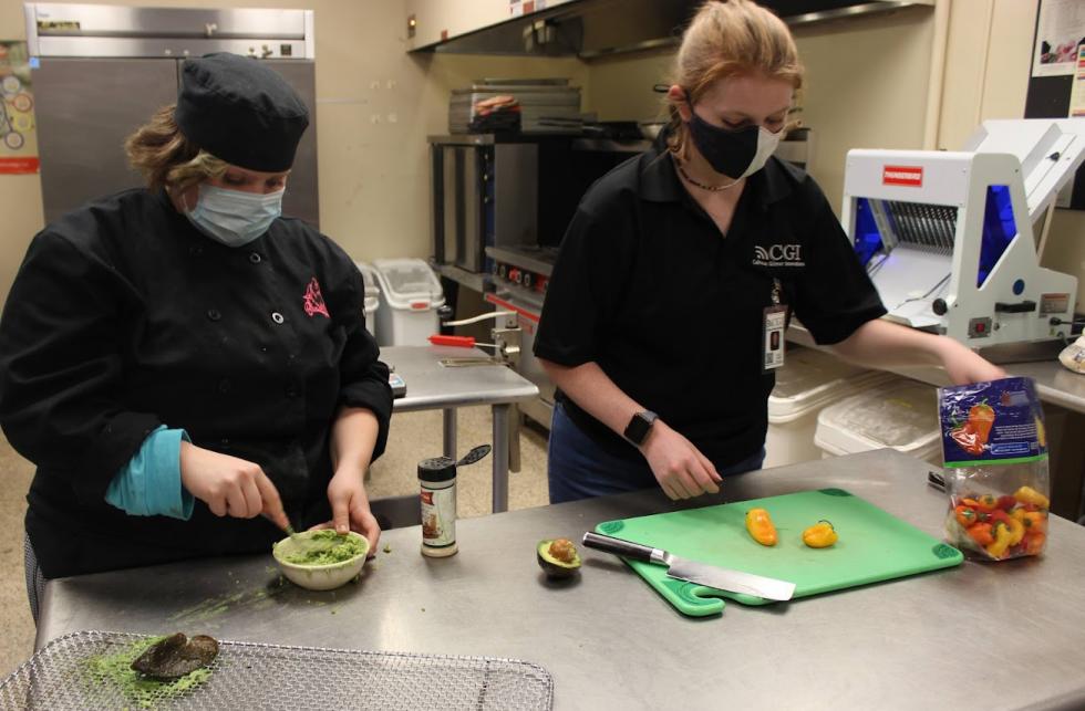 Tori Arnold of Calhoun-Gilmer Innovations and Pepper McCormick from Coyote Beautiful prepare a test recipe for the cookbook.