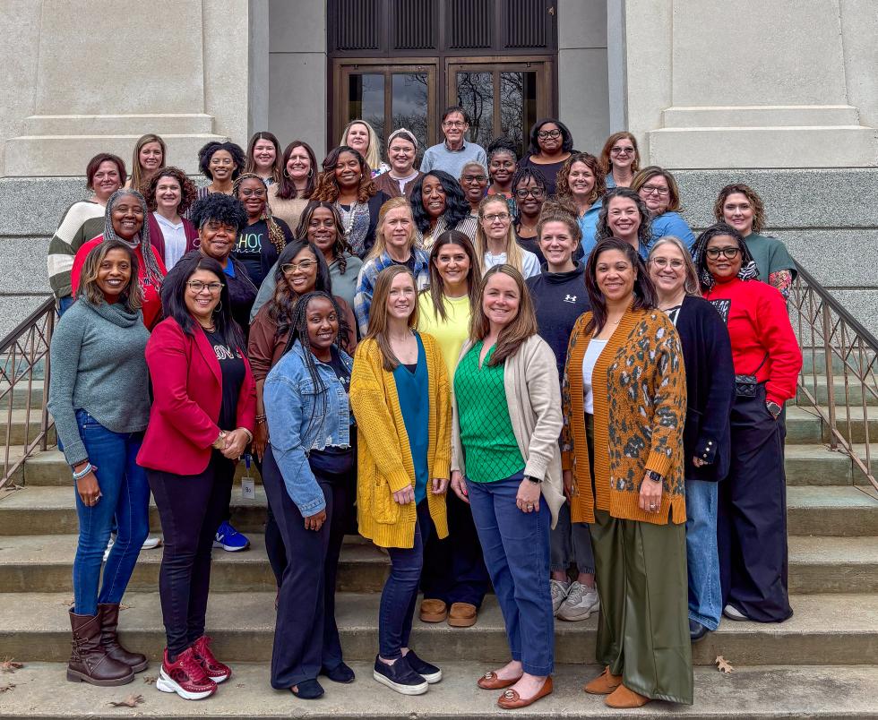 All 34  counselors stand on marble steps for a group picture