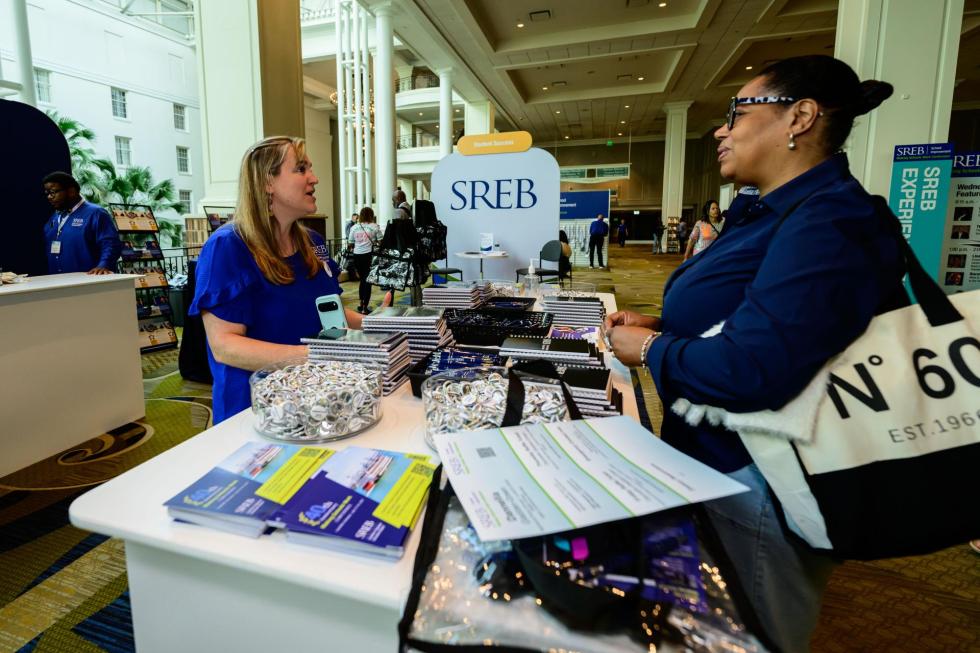 An SREB team member talks to an attendee at the 2026 community hub