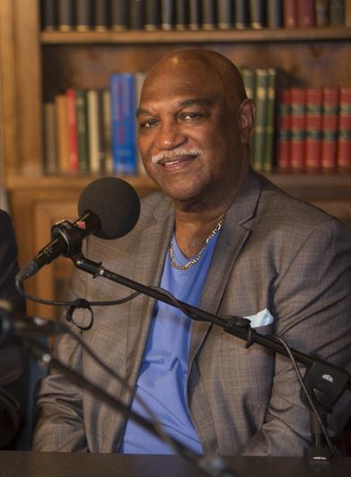 Dr. Robert (Bob) Belle poses for a photo behind a microphone.