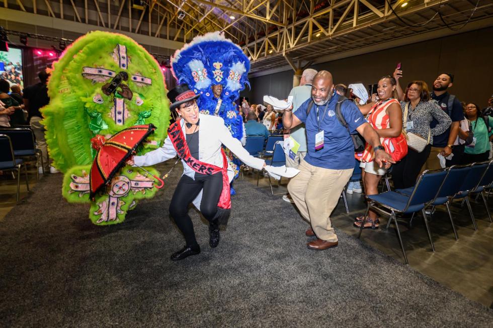 Attendees dance and join the band as they exit the keynote session of the 2025 confernece