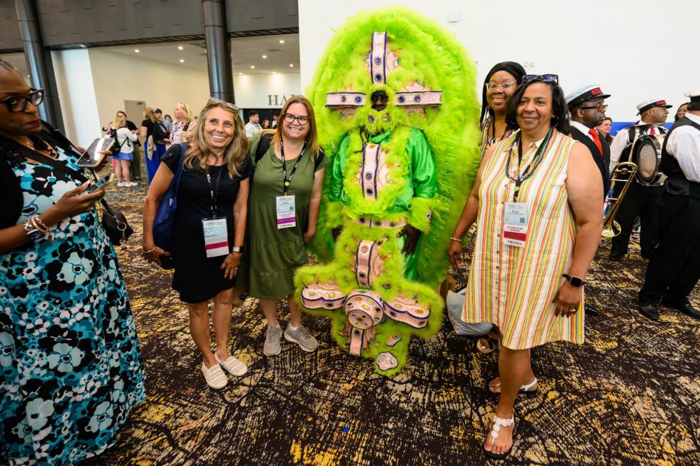 2025 attendees pose with a Mardi Gras Indian