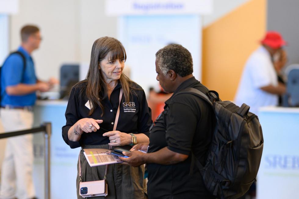2025 attendee asks an SREB team member for assistance