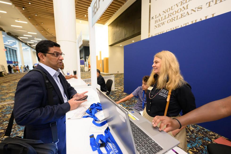 Rebecca Holt helping an attendee at the 2025 conference