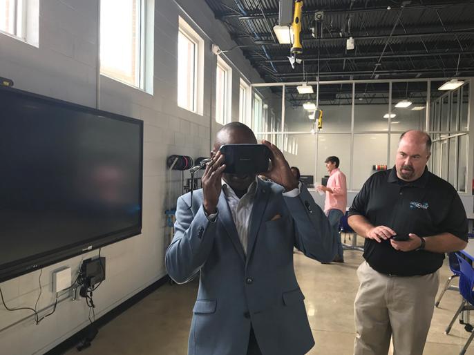 Alabama State Senator Bobby D. Singleton tries out one of Lab 212’s virtual reality headsets as Robert Mayben, a trainer with Alabama Technology in Motion, looks on.