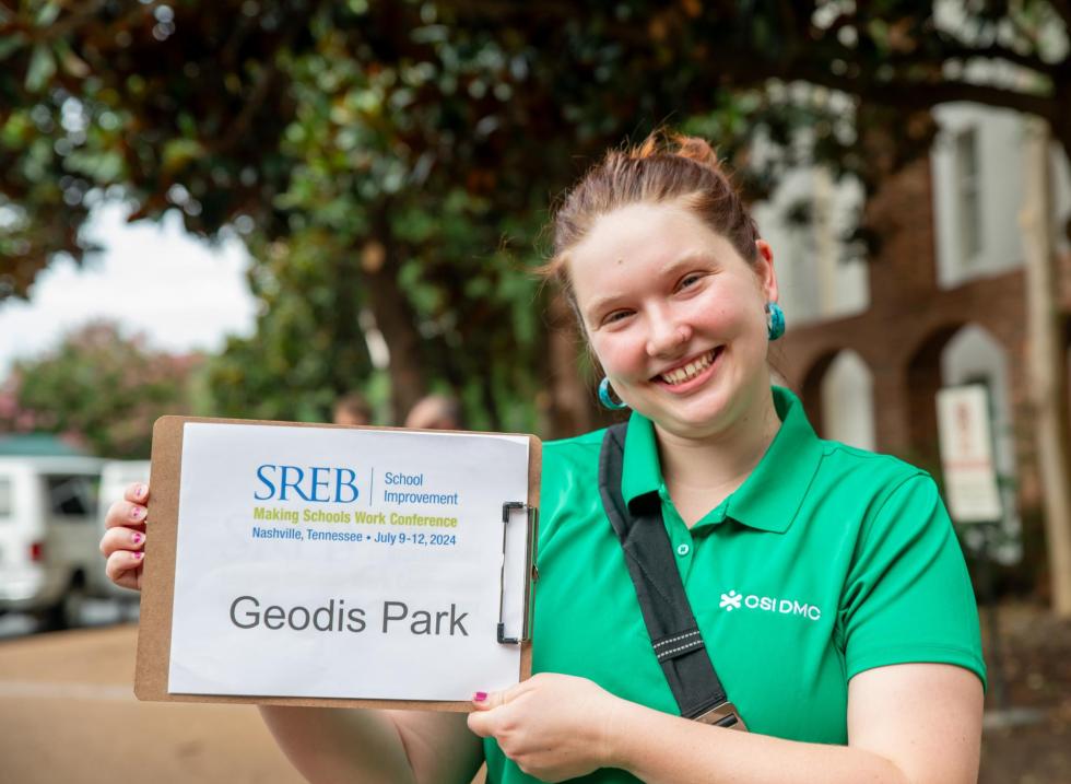 A representative holds up a sign for one of our 2024 industry partners. 