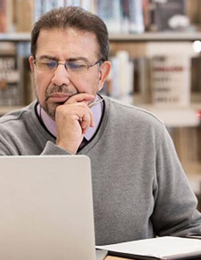 Decorative picture of an adult man on a computer.