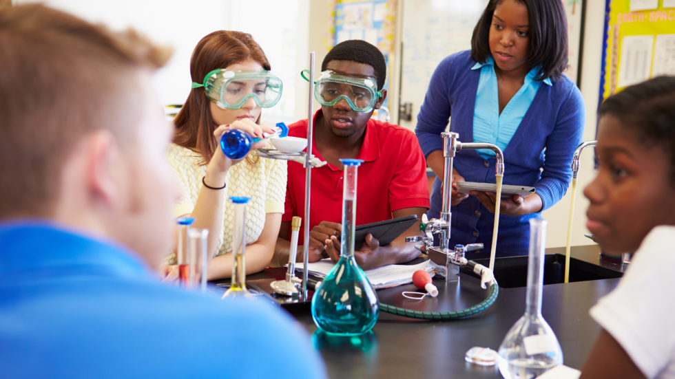 Science teacher working on a lab with students.