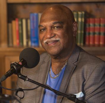 Dr. Robert (Bob) Belle poses for a photo behind a microphone.