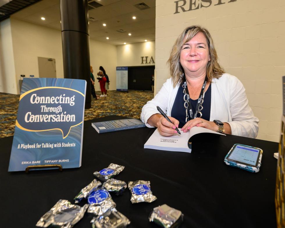An author sets up her book signing table at the 2025 conference