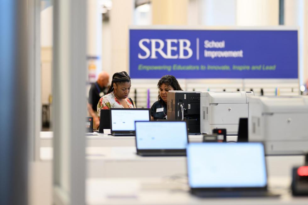 An SREB team member helps an attendee register at the 2025 conference