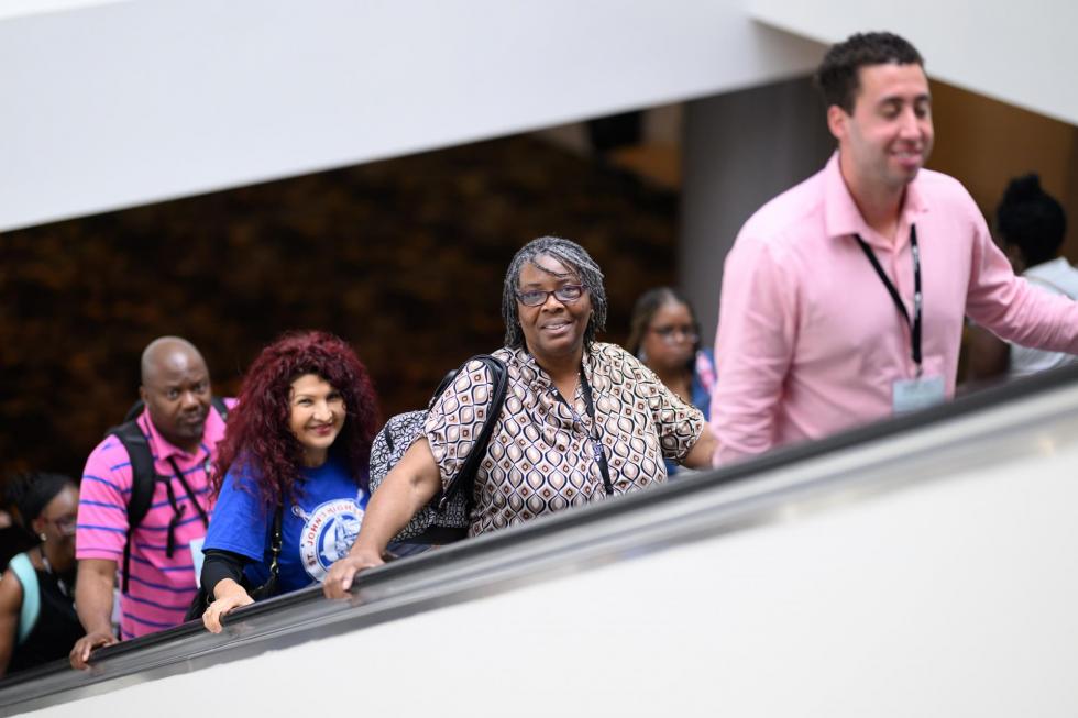 2025 attendees ride the escalotor to the second floor